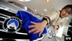 Una empleada del Zhejiang Geely Holding Group limpia un vehículo de la marca Gelly.