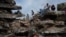 Ciudadanos de La Guaira alrededor de un edificio destruido por el terremoto del pasado 24 de junio, en Venezuela. (AP)