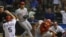 El receptor de los Angelinos de Los Ángeles Daniel Stange trata de coger la bola mientras Ian Kinsler (izda), de los Vigilantes de Texas, consigue llegar a la base...