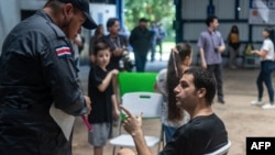 Un oficial de policía habla con un migrante durante una visita de prensa al Centro de Atención Temporal para Migrantes (Catem) en Puntarenas, Costa Rica, el 31 de marzo de 2025.