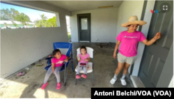 Elizabeth junto a sus dos hijas en el portal de su casa en Fort Myers, Florida, horas después del paso del huracán Milton.