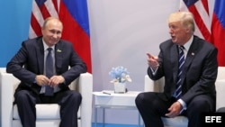  El presidente ruso, Vladímir Putin, conversa con el presidente estadounidense, Donald J. Trump (d).