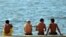 Varios jóvenes conversan en el Malecón habanero.
