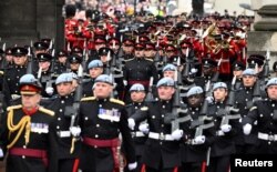 Cientos de soldados con uniformes escarlata y sombreros negros de piel de oso se alineaban a lo largo de The Mall, el gran bulevar que conduce al palacio, en lo que constituye el mayor acto ceremonial de este tipo en Gran Bretaña desde la coronación de la madre de Carlos.