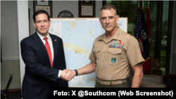 El secretario de Estado Marco Rubio estrechando la mano del general Francis L. Donovan (comandante del SOUTHCOM) ante un mapa de Cuba, durante la Conferencia de Jefes de Misión de 2026, celebrada en la sede del SOUTHCOM en Doral, Florida.