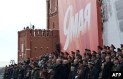 En esta fotografía de grupo distribuida por la agencia estatal rusa Sputnik, el presidente ruso Vladimir Putin pronuncia un discurso durante el desfile militar del Día de la Victoria en la Plaza Roja en el centro de Moscú el 9 de mayo de 2024.