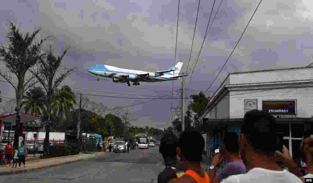 Un grupo de cubanos observa el paso del Air Force One, el avión presidencial estadounidense, sobre la localidad de Santiago de las Vegas.