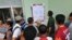 Varias personas leen una cartelera en una oficina municipal de trabajo.