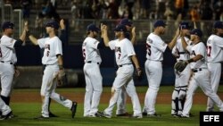 Los jugadores estadounidenses se saludan después de derrotar a Cuba 5-2 carreras.