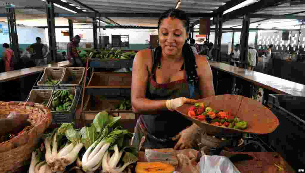 Una mujer vende vegetales en un mercado agropecuario de La Habana.