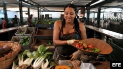 Una mujer vende vegetales en un mercado agropecuario de La Habana.