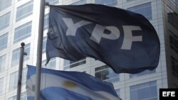 Detalle de las banderas de Argentina y de la petrolera YPF frente al edificio donde funcionan las oficinas centrales de la empresa en Buenos Aires. 