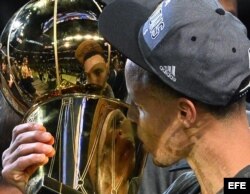 Curry besa el trofeo ganado por los Warriors de Golden State, campeones de la NBA 2015.