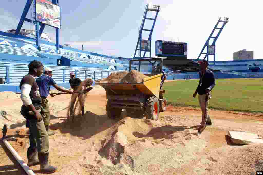 Trabajadores del estadio Latinoamericano de béisbol realizan labores de mantenimiento.