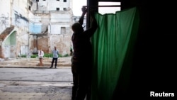 Un hombre prepara un colegio electoral en Cuba.