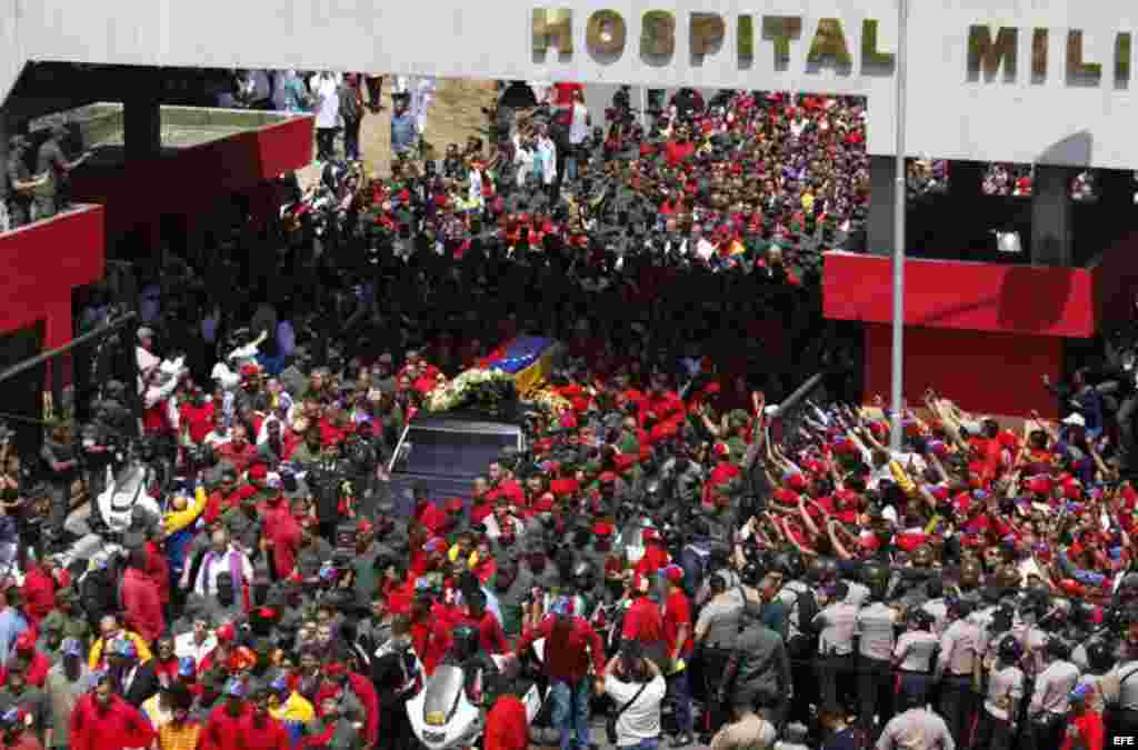 El féretro de Hugo Chávez, es acompañado por cientos de seguidores hoy, miércoles 6 de marzo de 2013, en una calle de Caracas (Venezuela). El Ataúd inició el recorrido desde el Hospital Militar Dr. Carlos Arvelo hasta la Academia Militar, donde el viernes
