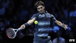 El tenista suizo Roger Federer devuelve una bola al francés Richard Gasquet, en su segundo partido de la fase de grupos de la Copa de Maestros, que se disputa en el pabellón O2 Arena de Londres, Reino Unido.
