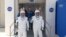 Los astronautas Bob Behnken (derecha) y Doug Hurley se dirigen hacia los vehículos que los transportaron a la rampa de lanzamiento de la cápsula SpaceX Crew Dragon, el 30 de mayo del 2020. (Foto AFP tomada de NASA TV)