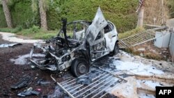 Imagen tomada en un hotel de la ciudad de Ashkelon, en el sur de Israel, muestra un coche destruido tras un ataque con cohetes desde la Franja de Gaz, el 10 de octubre de 2023. (JACK GUEZ/AFP)