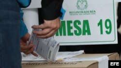 Un votante introduce su papeleta en una urna durante la segunda vuelta presidencial, en Bogotá.