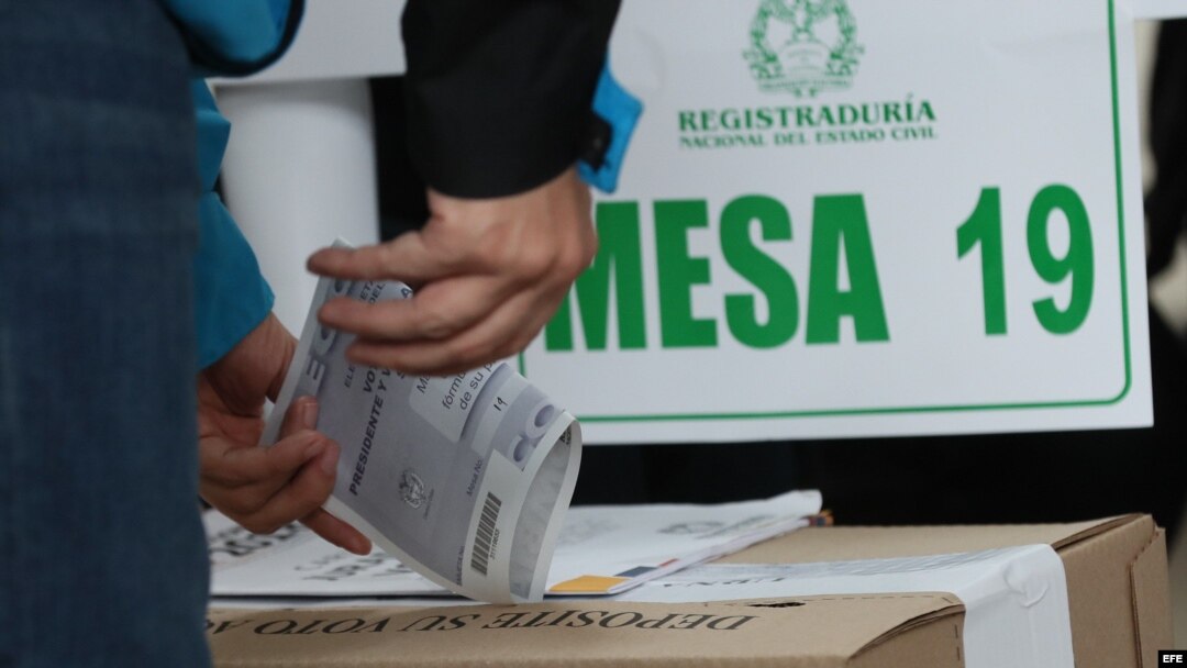 Un votante introduce su papeleta en una urna durante la segunda vuelta presidencial, en Bogotá.