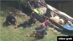 Cuatro inmigrantes cubanos descansan junto a su bote en el patio de una casa de Palmetto Bay.