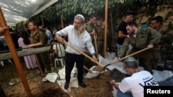 Voluntarios israelíes cavan nuevas tumbas para enterrar a más personas que fueron asesinadas en el ataque a Israel por parte de Hamás desde la Franja de Gaza, en el cementerio militar Monte Herzl en Jerusalén.