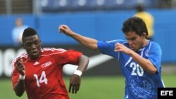 El jugador de El Salvador, Endres Flores, disputa el balón con Aricheel Hernandez de Cuba