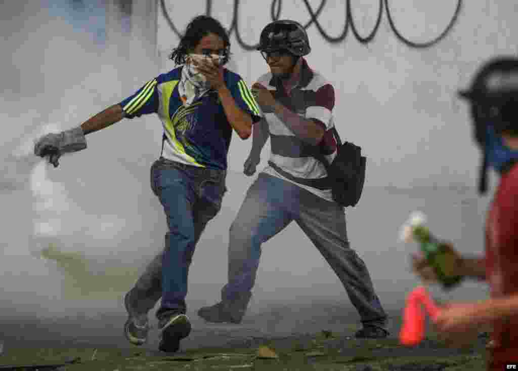 Jóvenes manifestantes se enfrentan con agentes de la Policía Nacional Bolivariana (PNB) en las calles de Caracas (Venezuela).