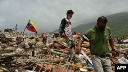 Familiares de personas desaparecidas buscan sus cuerpos entre los escombros de edificios colapsados ​​en Caraballeda, estado de La Guaira, Venezuela, el 10 de julio de 2026, tras los terremotos del 24 de junio.