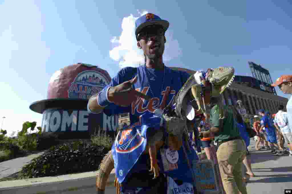 Seguidor de los Mets de Nueva York muestra un par de iguanas antes del juego de las Estrellas de las Grandes Ligas en el Citi Field en Flushing, Nueva York (EE.UU.). 