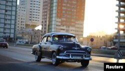 Un almendrón circula por el Malecón de La Habana. 