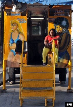 Una mujer cobra la entrada a un baño público móvil en una calle Santiago de Cuba (Cuba).