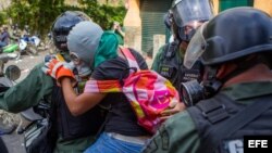 Miembros de la Guardia Nacional Bolivariana detienen a una joven