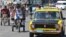 Mientras algunas personas se movilizan por las calles de La Habana en Bicitaxis (i) los taxistas intentan recuperar el terreno perdido...
