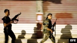 Rebeldes sirios patrullan por las calles de Alepo, Siria. 