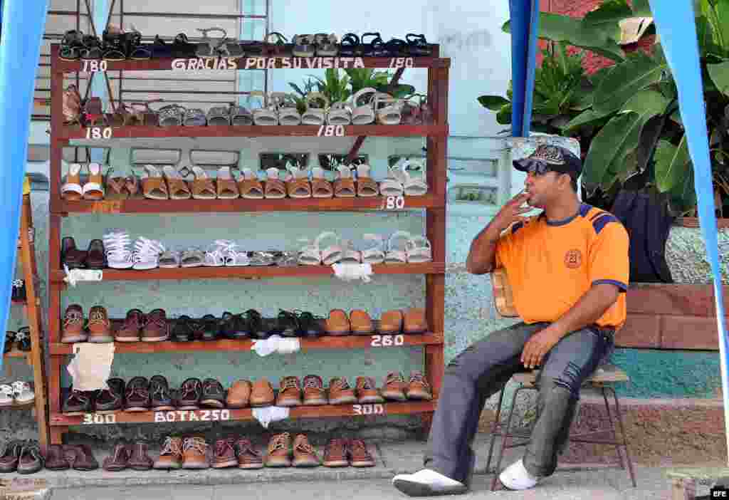 Un artesano vende zapatos en un puesto callejero. Los cueros sin curtir y curtidos, pieles, artículos de talabartería y arneses, bolsos y artículos de viaje están permitidos.