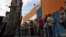 Un grupo de personas aguardan afuera del supermercado Día a Día para ingresar y hacer compras, bajo presencia militar, en la ciudad de Caracas (Venezuela). 