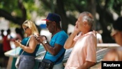 Cubanos conectados a Internet desde un punto WI-Fi en Habana.