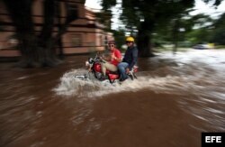 Dos hombres transitan en moto por una calle inundada este viernes 29 de noviembre de 2013, en La Habana