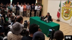 El gobernador del estado mexicano de Guerrero, Ángel Aguirre (d), habla durante una rueda de prensa hoy, jueves 23 de octubre de 2014, donde anunció que se separa del cargo tras el aumento de las protestas por la desaparición de 43 estudiantes 
