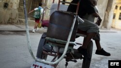  Un bicitaxista toma una siesta sentado en su vehículo en una calle de La Habana (Cuba). 