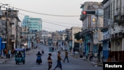 Personas cruzan una calle mientras se restablece la red eléctrica nacional de Cuba tras su colapso —el tercer apagón masivo en nueve días—, en La Habana, Cuba, el 15 de julio de 2026. REUTERS/Norlys Perez
