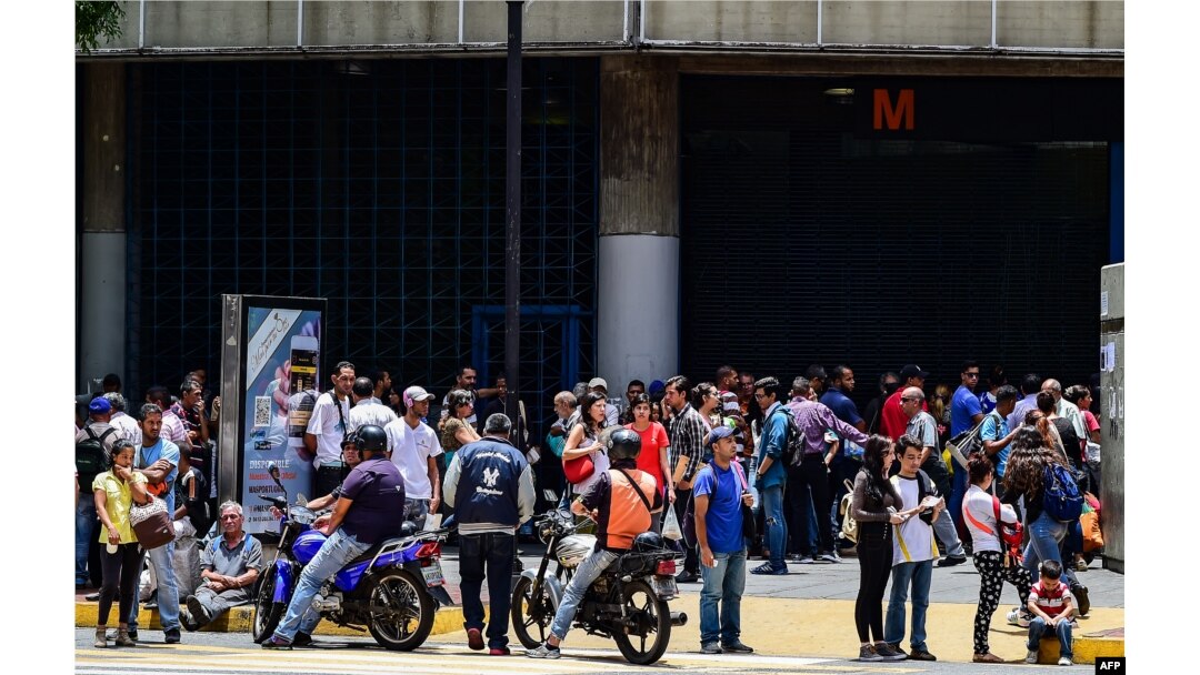 Venezolanos esperan frente a una estación del metro, en Caracas, durante un apagón que afectó a gran parte de la capital venezolana.