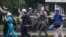 Un grupo de paramédicos voluntarios caminan con sus manos en alto en medio de los intentos de la Policía Nacional Bolivariana (GNB) por dispersar un grupo de manifestantes opositores al Gobierno.