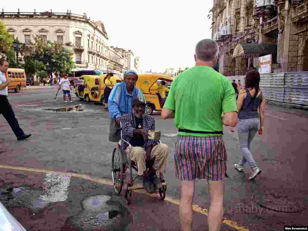 Un hombre pide dinero a un turista en una calle de La Habana. (Foto: Yusnaby Pérez)