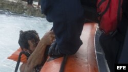 Fotografía de archivo cedida por la Guardia Costera de EE.UU. que muestra a un agente mientras ayuda a un exiliado cubano interceptado en alta mar el 9 de diciembre de 2015, en Miami (FL, EE.UU.). Un total de 7.358 cubanos que intentaron llegar ilegalmente