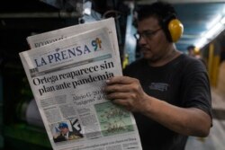 Trabajador de la prensa revisa edición después de que Ortega hablara sobre coronavirus