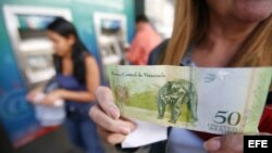 Una mujer sostiene el bolívar fuerte, en Caracas, Venezuela. q