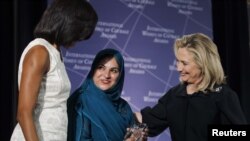 La secretaria de Estado Hillary Clinton y la primera dama Michelle Obama felicitan a Shad Begum, de Pakistán.